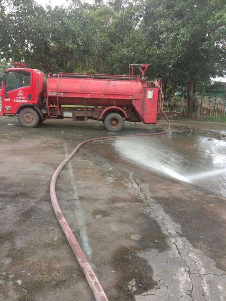 เจ้าหน้าที่ อบต.อุดมทรัพย์ นำรถบรรทุกน้ำฉีดพ่นน้ำล้างทำความสะอาดสนามกีฬาโรงเรียนบ้านบะใหญ่
